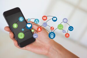Composite image of hand holding smartphone with smartphone icons
